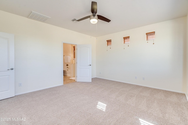 spare room with baseboards, visible vents, a ceiling fan, and light colored carpet