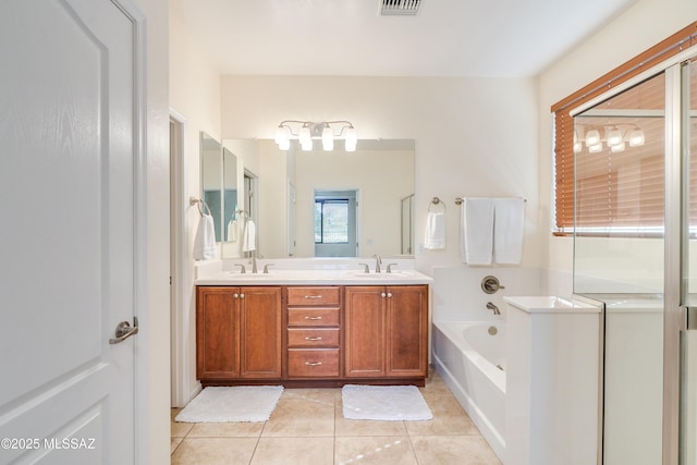 bathroom with tile patterned flooring, a garden tub, a sink, and double vanity