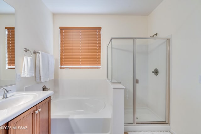 full bath featuring a stall shower, a garden tub, and vanity