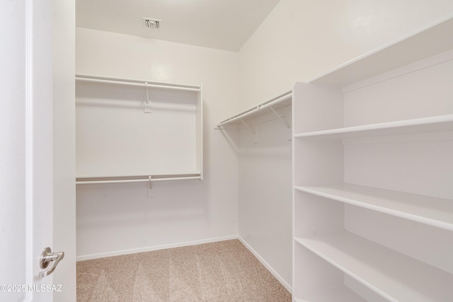 walk in closet featuring light carpet