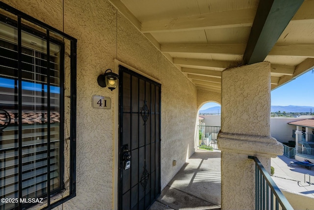 entrance to property with a mountain view and stucco siding