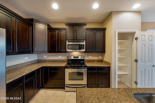 10365 S High Bluff Dr, Vail, AZ 85641 - kitchen with stainless steel appliances, dark brown cabinets, light tile patterned flooring, recessed lighting, and stone countertops