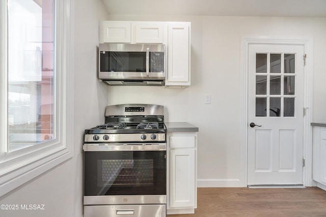 kitchen with light wood-style flooring, white cabinetry, and stainless steel appliances