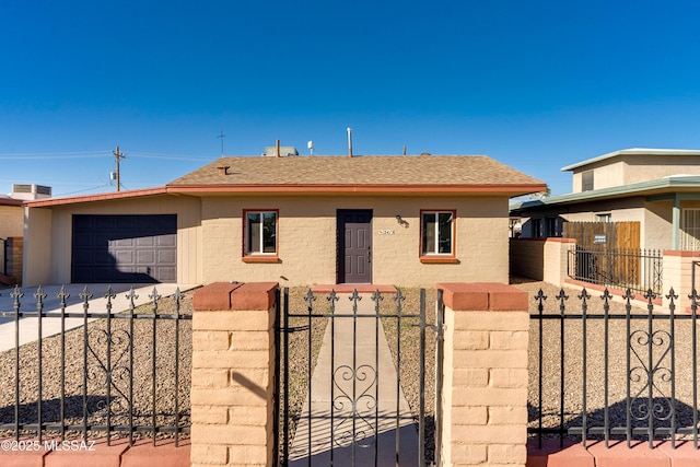 view of front of house with a fenced front yard, a garage, brick siding, driveway, and a gate