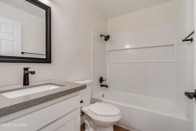 bathroom with washtub / shower combination, vanity, and toilet