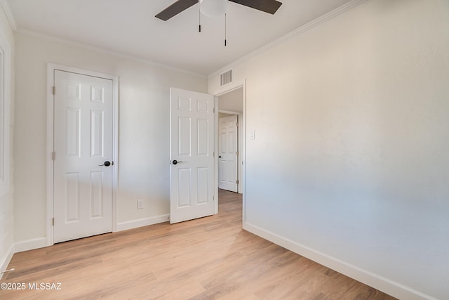 unfurnished bedroom featuring ornamental molding, light wood-style flooring, and baseboards