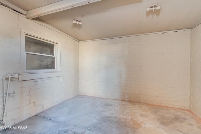 spare room with brick wall and concrete flooring