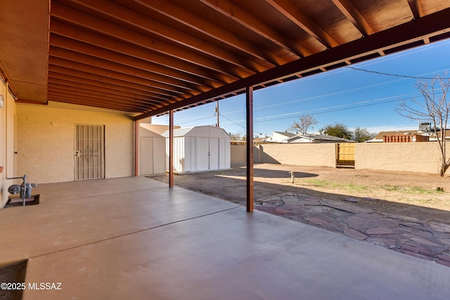 view of patio featuring a fenced backyard, an outdoor structure, and a storage shed