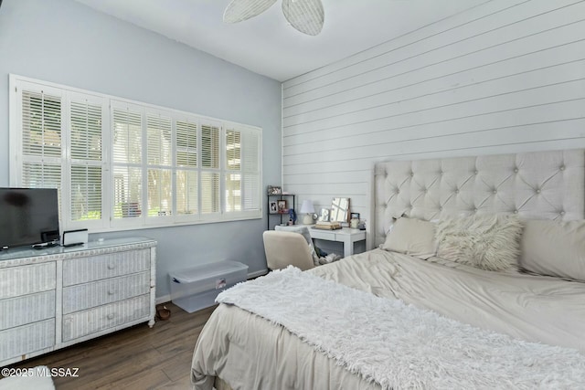 bedroom featuring dark wood-type flooring and wooden walls