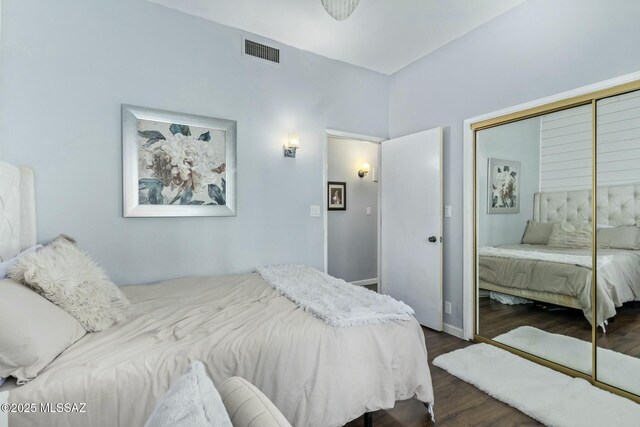 bedroom featuring dark wood-type flooring, a closet, and visible vents