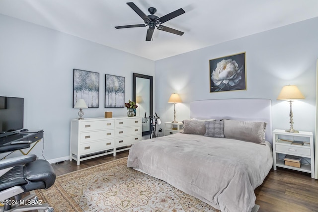 bedroom featuring dark wood-style floors, a ceiling fan, and baseboards