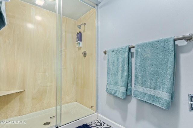 full bathroom featuring a shower stall and baseboards