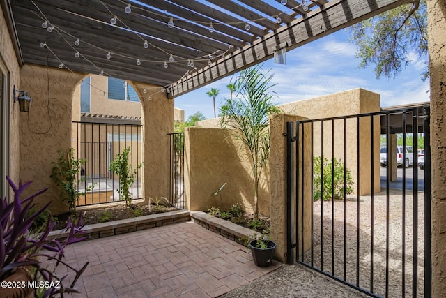 view of patio / terrace featuring a gate, fence, and a pergola