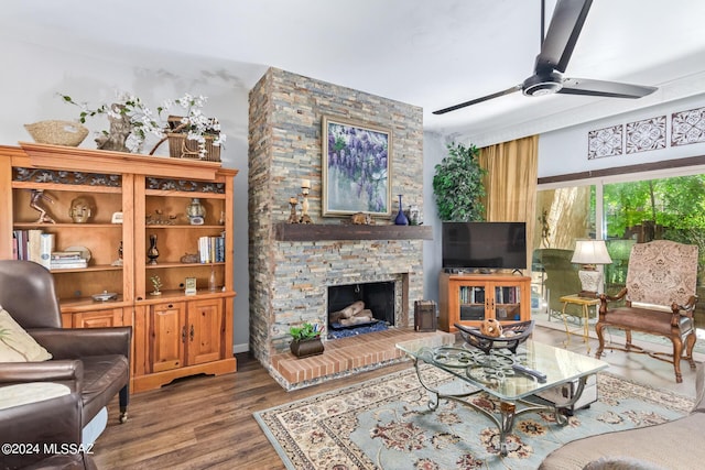 living room featuring a fireplace, a ceiling fan, and wood finished floors