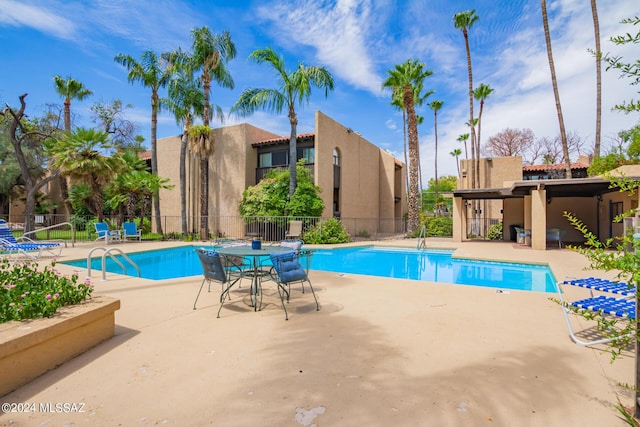 community pool featuring a patio and fence