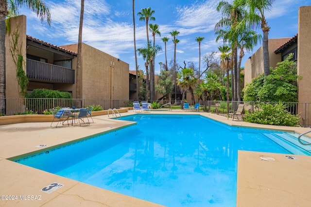 community pool featuring a patio area and fence