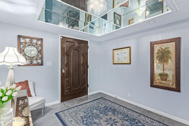 tiled entryway with a high ceiling and baseboards