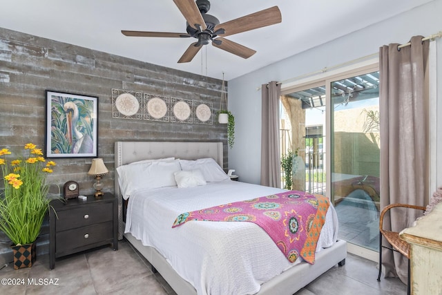 bedroom featuring access to exterior, an accent wall, and a ceiling fan
