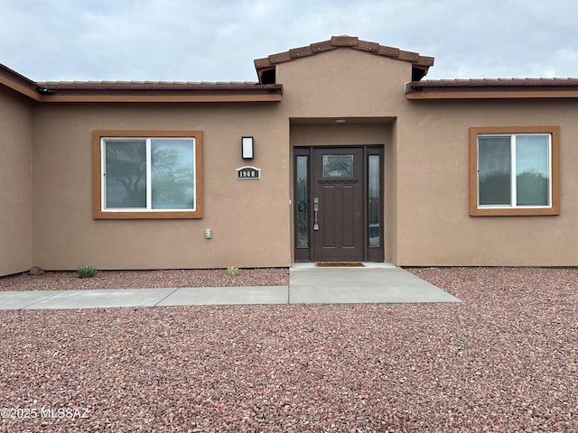 view of exterior entry featuring stucco siding