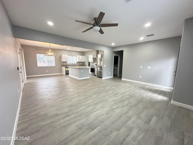 unfurnished living room featuring ceiling fan, light wood-type flooring, and visible vents