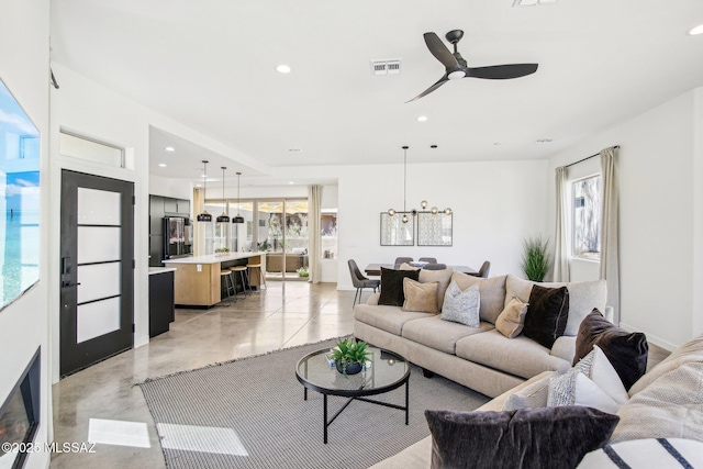 living area with finished concrete flooring, visible vents, a ceiling fan, and recessed lighting