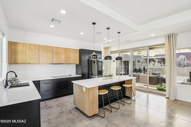 kitchen with visible vents, a kitchen island, a sink, concrete floors, and black electric cooktop