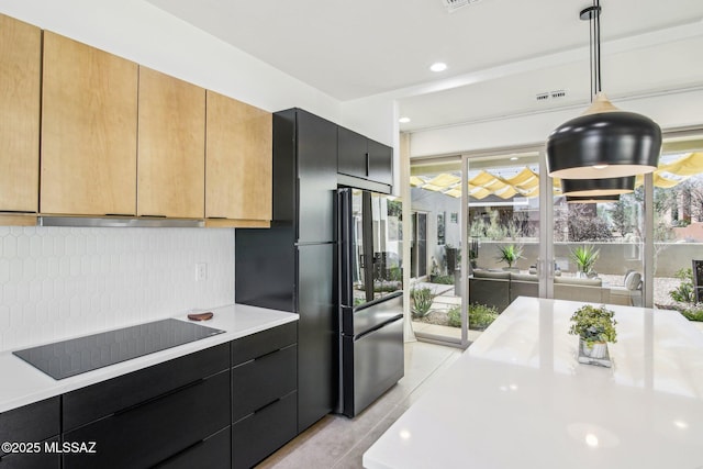 kitchen with light countertops, hanging light fixtures, extractor fan, and black electric cooktop