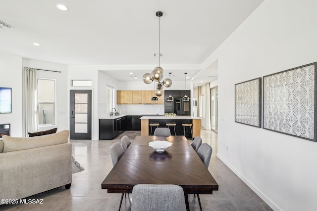 dining room featuring recessed lighting, finished concrete flooring, baseboards, and an inviting chandelier