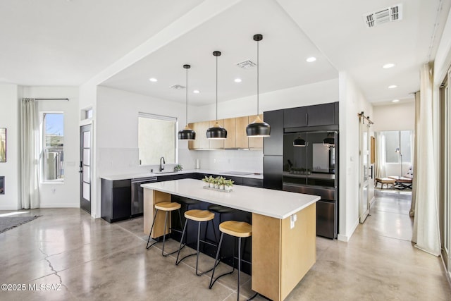 kitchen featuring a barn door, concrete floors, visible vents, a center island, and a kitchen bar