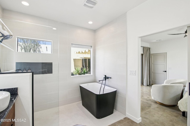 full bathroom with ceiling fan, tile patterned flooring, vanity, a freestanding bath, and walk in shower