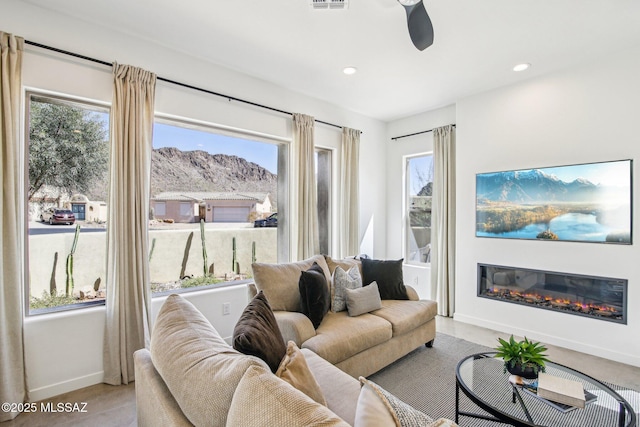 living area featuring ceiling fan, recessed lighting, visible vents, baseboards, and a glass covered fireplace