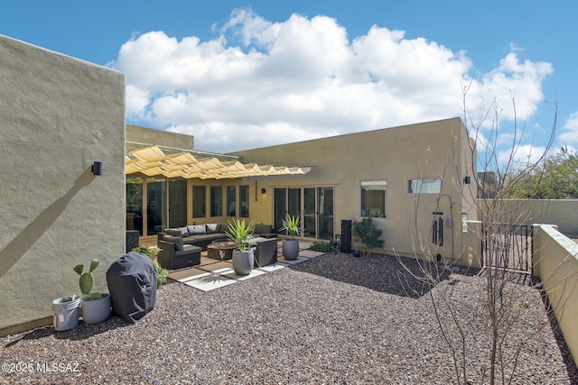 back of house featuring a patio area, a fenced backyard, an outdoor living space, and stucco siding