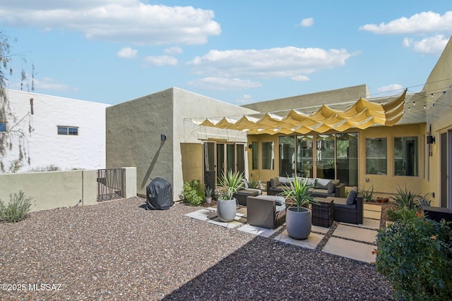 rear view of house featuring stucco siding, a patio area, and an outdoor hangout area