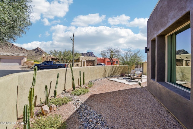 view of yard featuring a patio area, fence private yard, and a mountain view