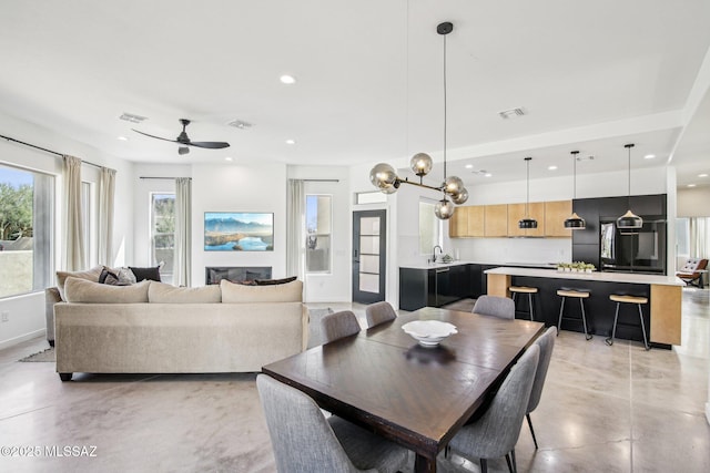 dining room featuring a ceiling fan, recessed lighting, visible vents, and finished concrete flooring