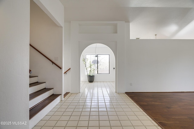 foyer featuring stairs and light tile patterned floors