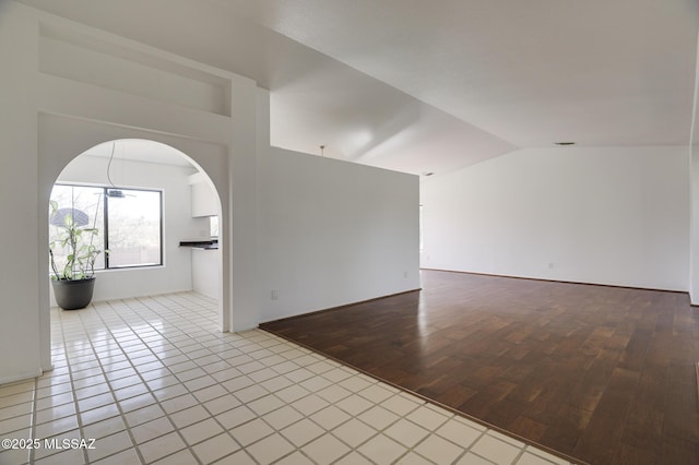 unfurnished room with lofted ceiling and wood finished floors