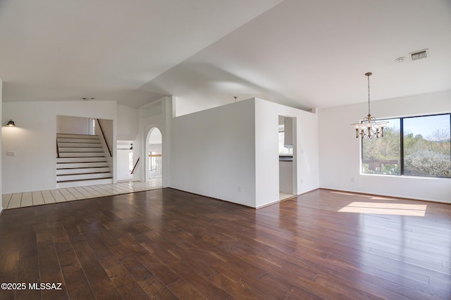 unfurnished living room with stairway, dark wood finished floors, visible vents, and an inviting chandelier