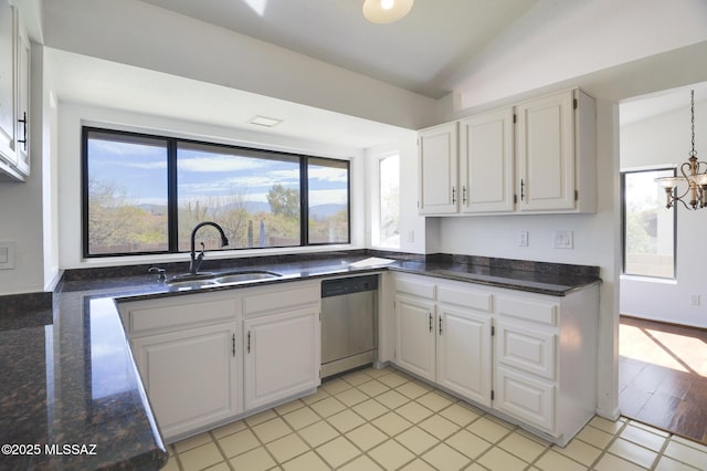 kitchen featuring vaulted ceiling, white cabinetry, a sink, and stainless steel dishwasher