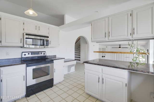 kitchen with arched walkways, stainless steel appliances, and white cabinetry