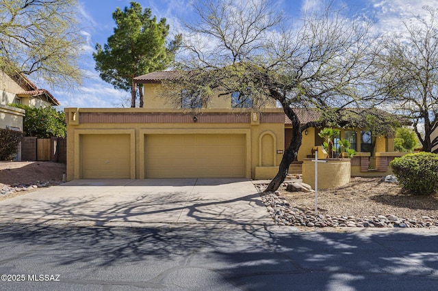 view of front facade featuring a garage, a tiled roof, concrete driveway, and stucco siding