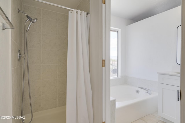 full bath with a stall shower, tile patterned flooring, a bath, and vanity