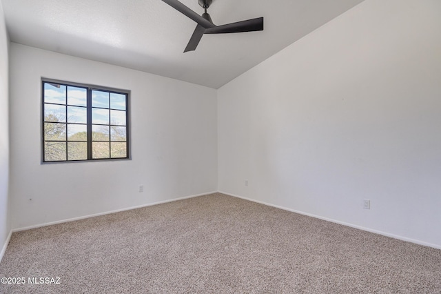 empty room featuring lofted ceiling, carpet flooring, a ceiling fan, and baseboards