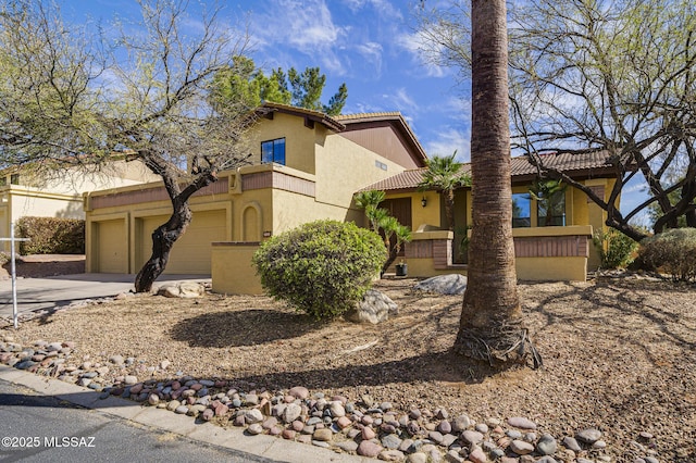 mediterranean / spanish-style house featuring concrete driveway, a tiled roof, an attached garage, and stucco siding