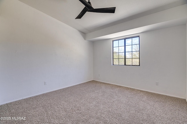 carpeted spare room featuring lofted ceiling, a ceiling fan, and baseboards