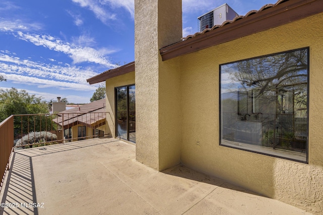 view of patio featuring central AC unit and a balcony