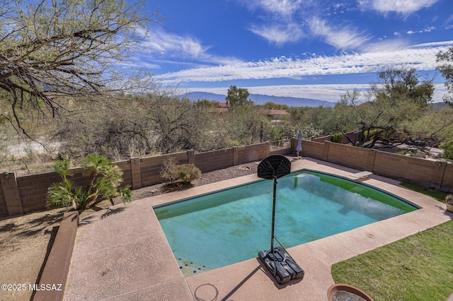 view of swimming pool with a fenced in pool, a fenced backyard, and a mountain view