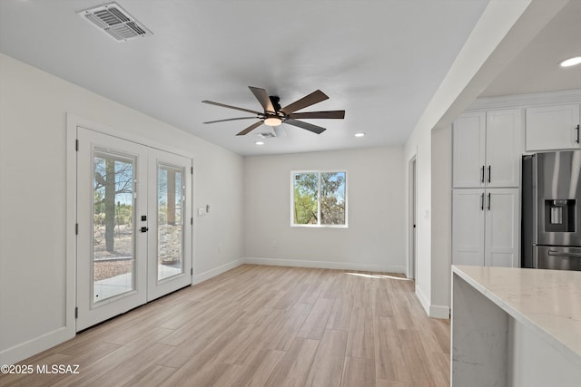 interior space with baseboards, french doors, visible vents, and light wood-style floors
