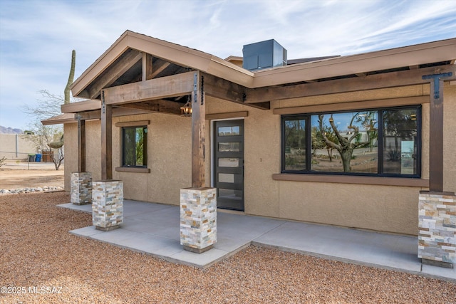 property entrance with a patio and stucco siding