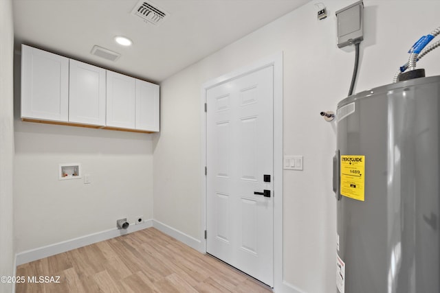 clothes washing area with cabinet space, baseboards, hookup for a washing machine, light wood-style floors, and water heater